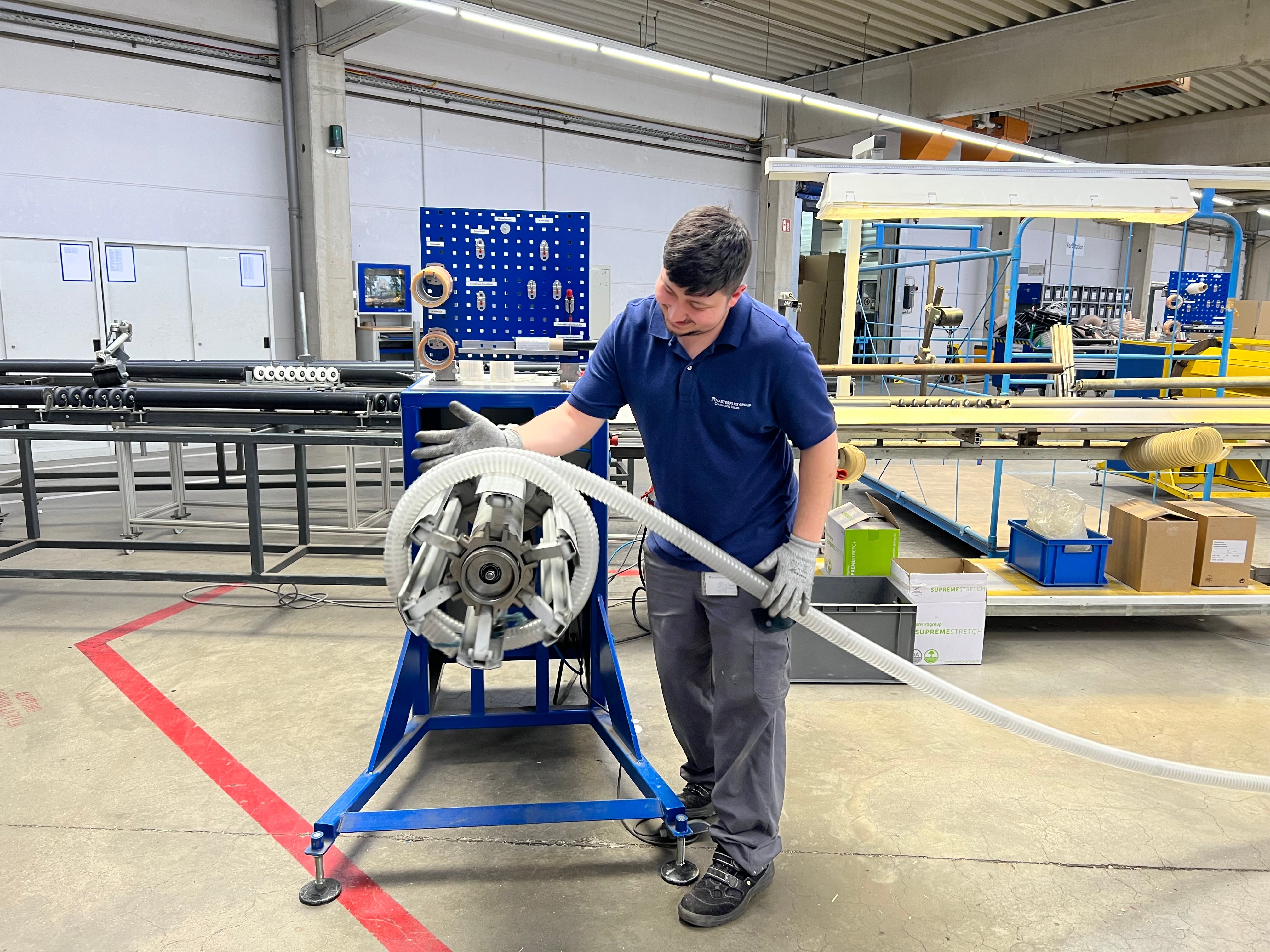 Beispielbild: Azubi beim Aufwickeln eines Schlauches