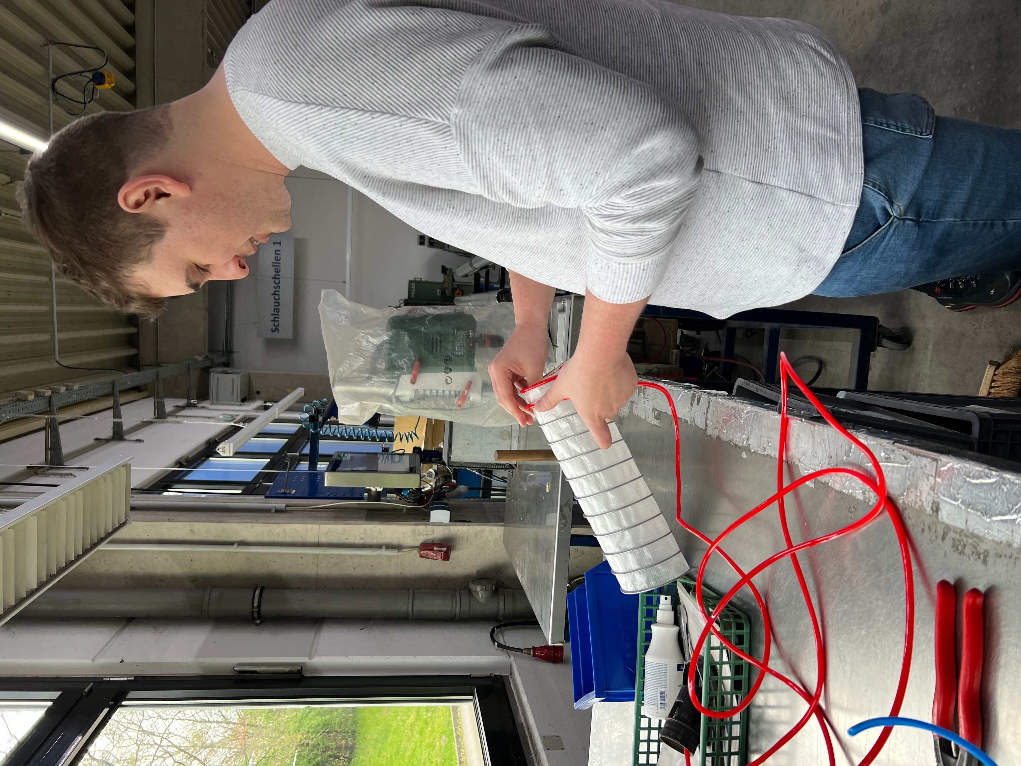 Beispielbild: Azubis bauen einen Schlauch zusammen