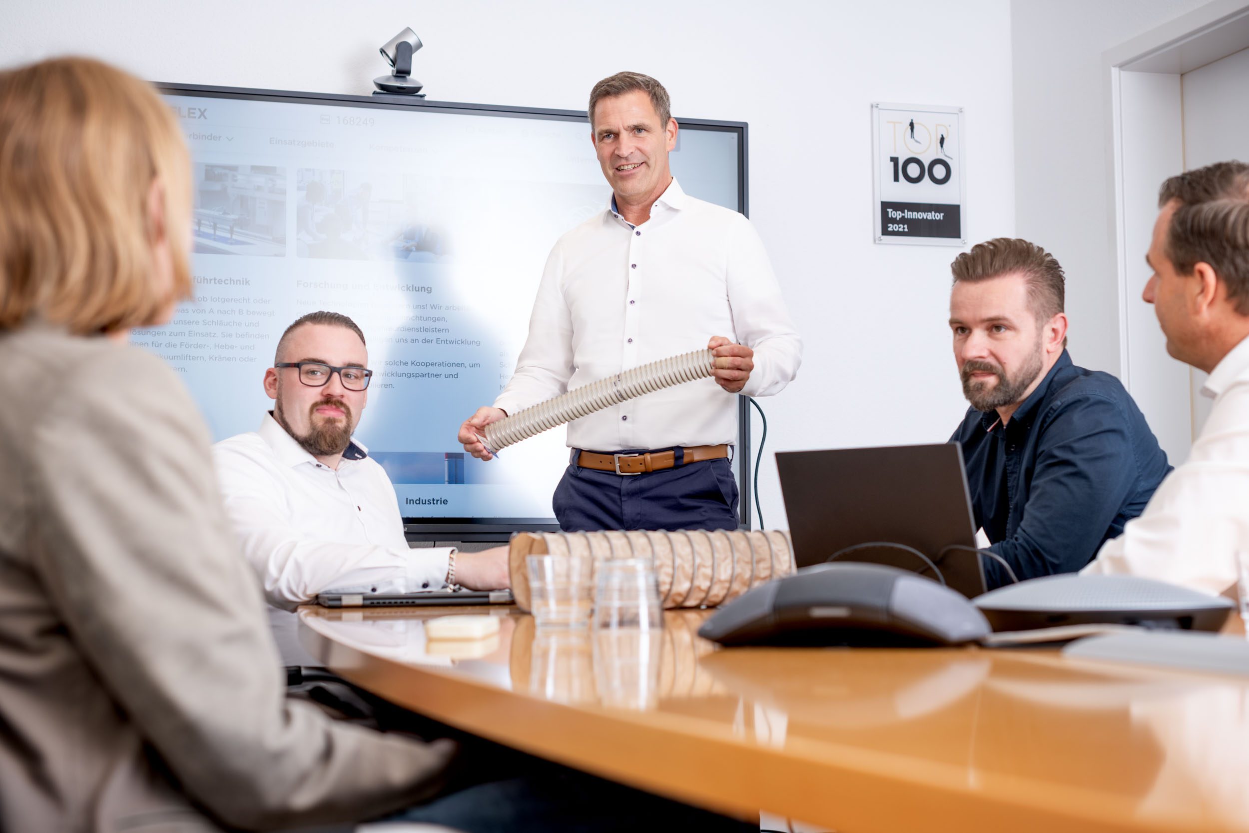 Example image: Employee with hose in hand in a meeting