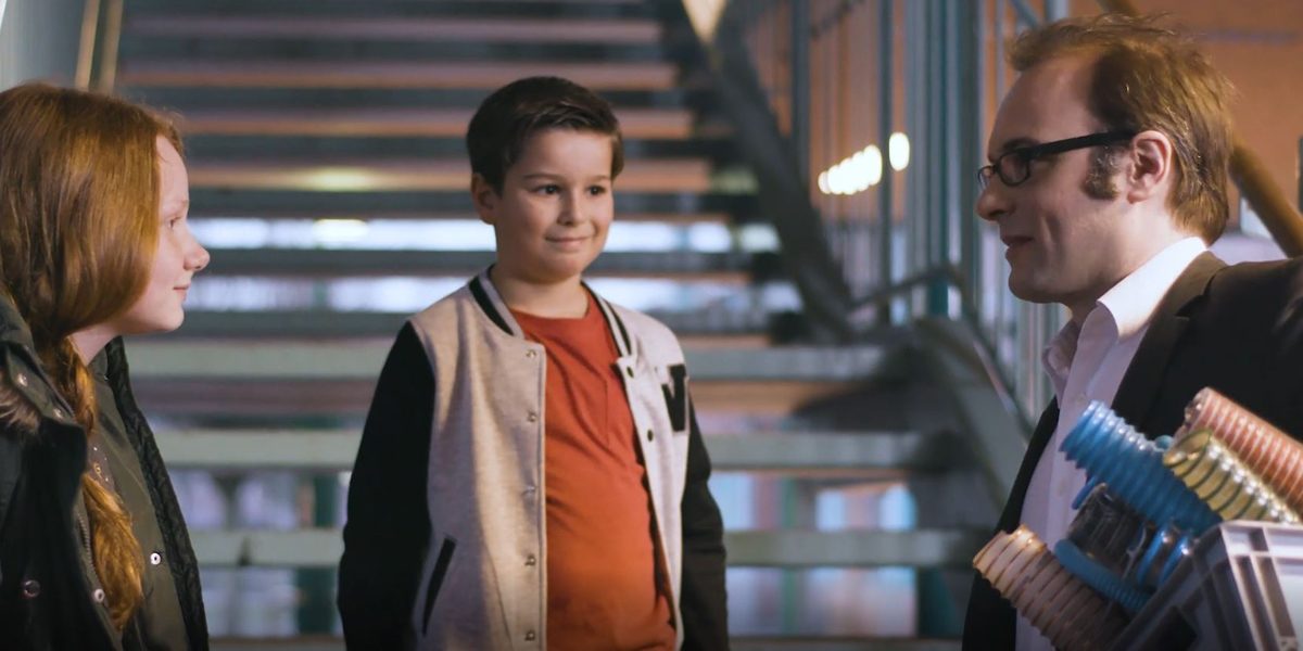 Three people face each other and talk