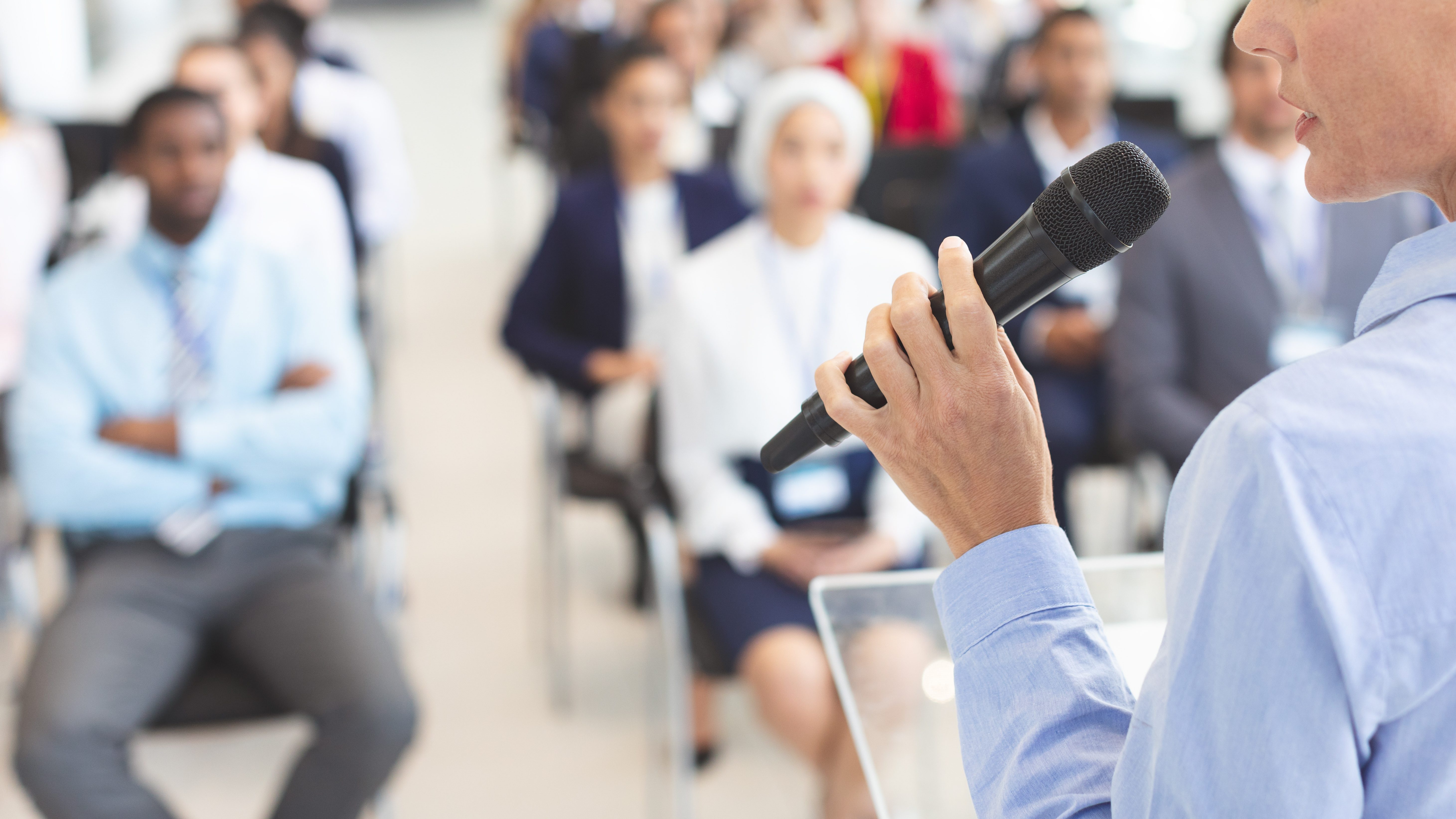 Stage: Speaker stands in front of an audience