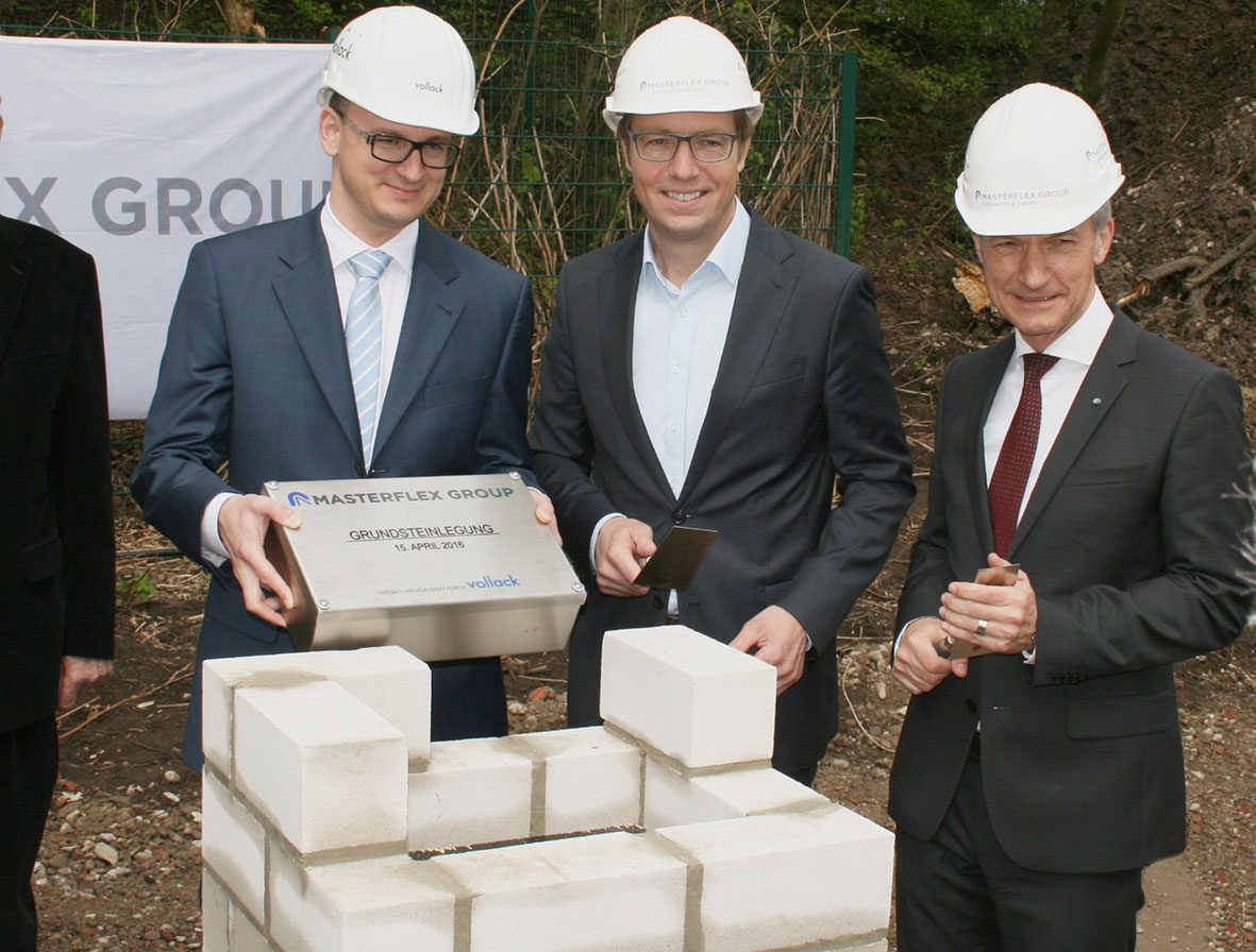 Masterflex Group, Masterflex: Grundsteinlegung in Gelsenkirchen zum Ausbau der Produktions- und Büroflächen, bei der Vorstandsvorsitzender Dr. Andreas Bastin, Thomas Kämpf Leiter M&A und Oberbürgermeister Frank Baranowski die Zeitkapsel in das Mauerwerk der neuen Hallen eingebettet haben 