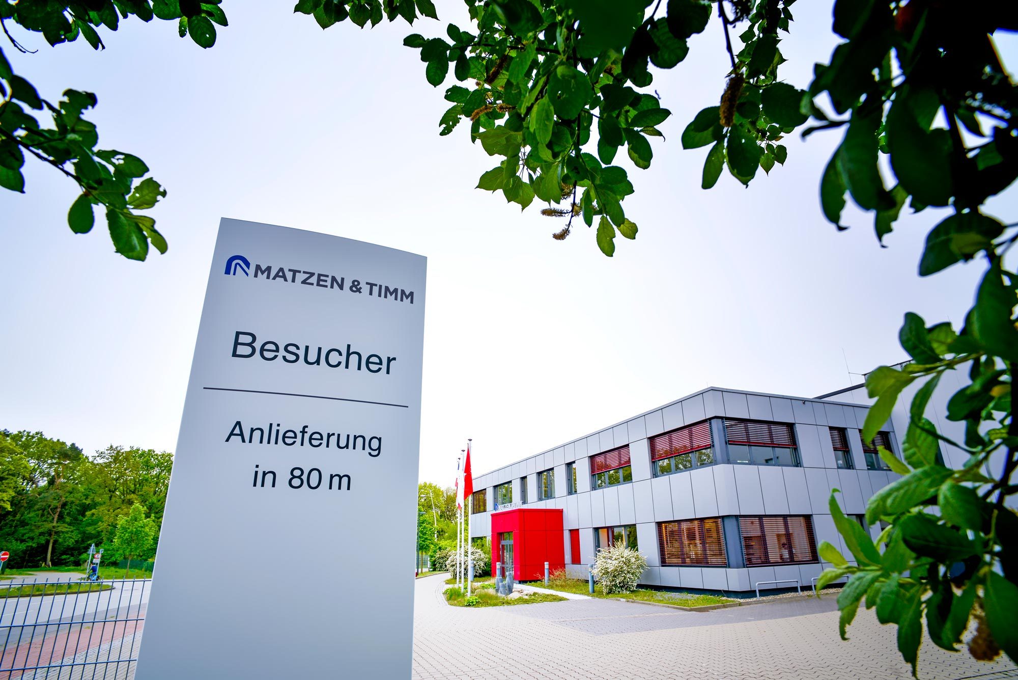 Gebäudeteil mit Hinweisschild Besucher und Anlieferung. 