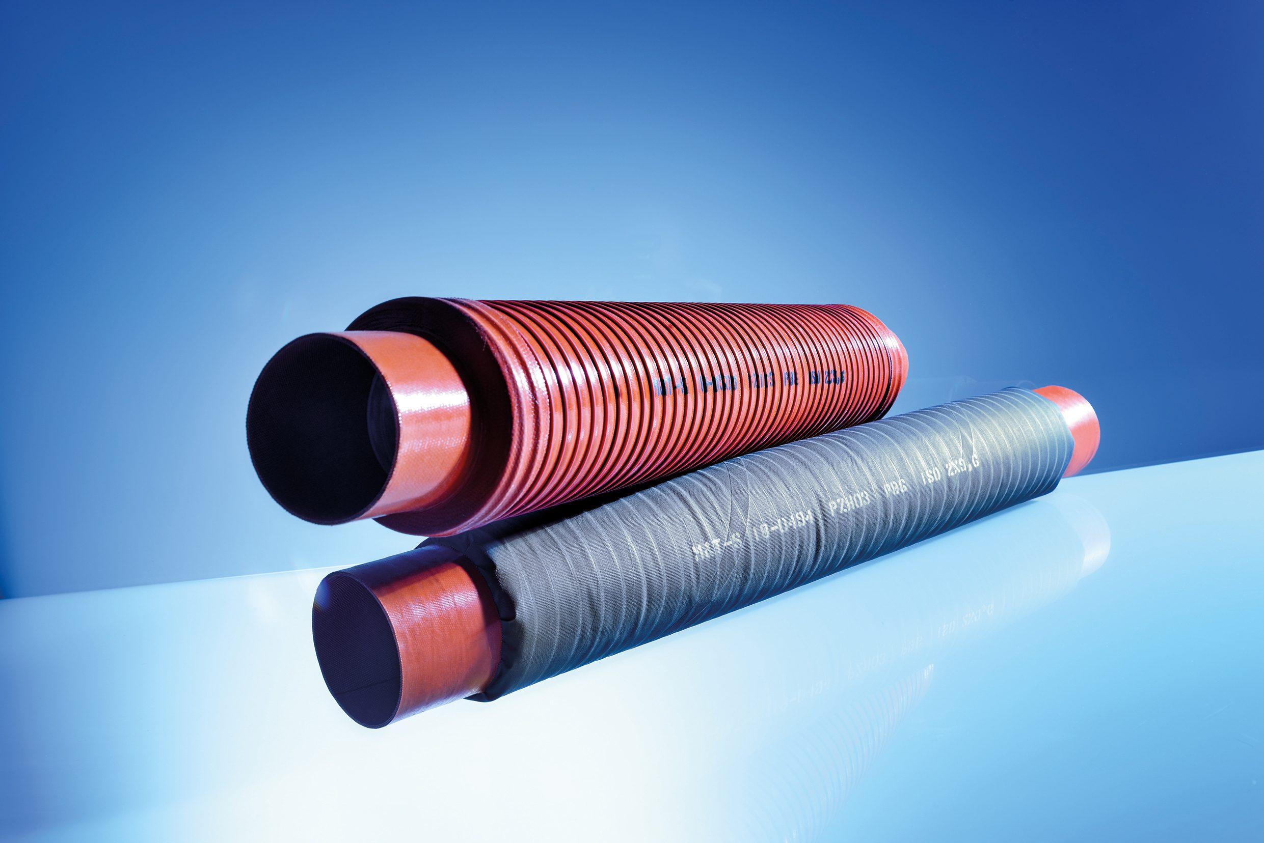 Two hand-wound tubes in rust brown and grey lying on the table.