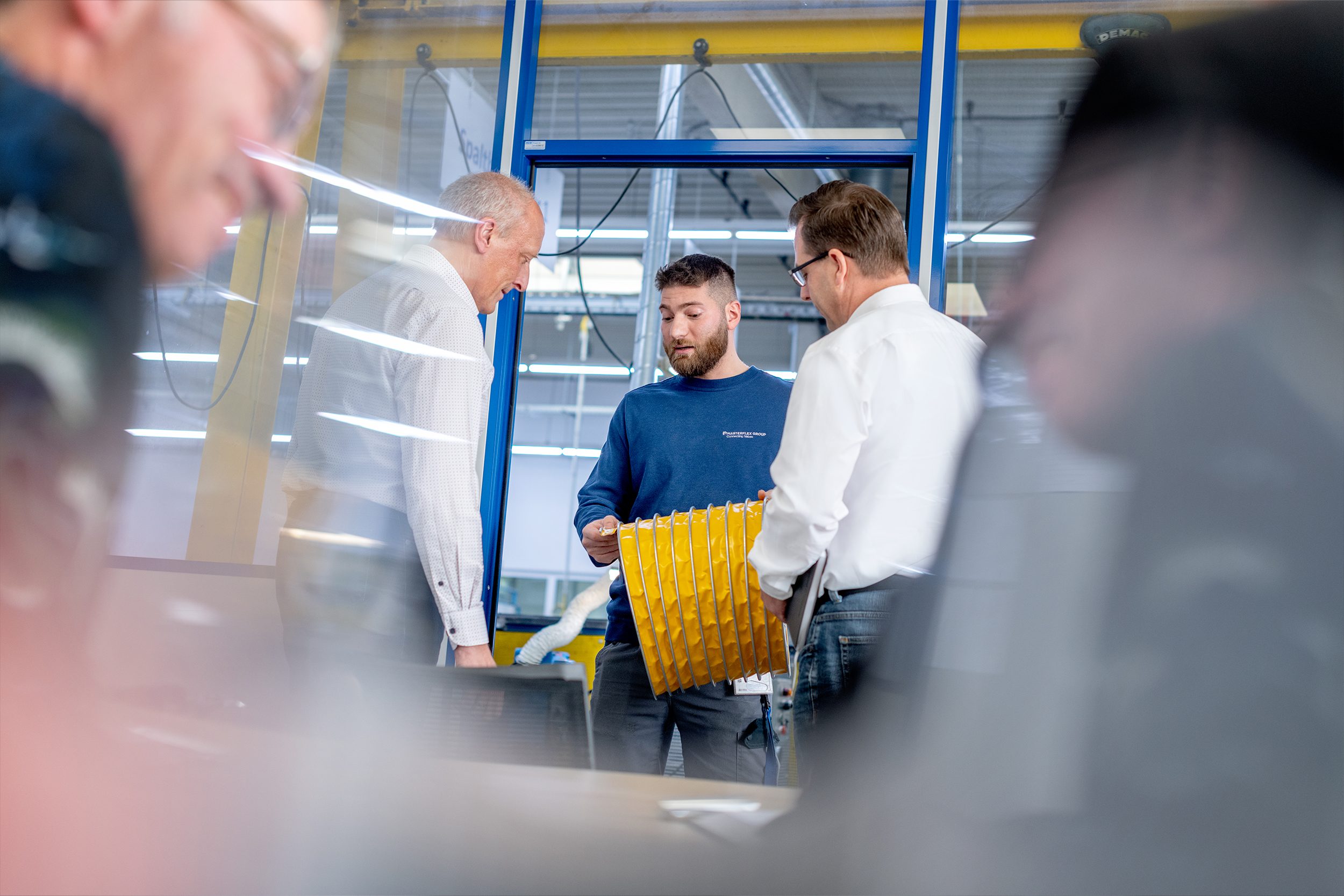 Nastrojowe zdjęcie: pracownicy Masterflex rozmawiający w magazynie