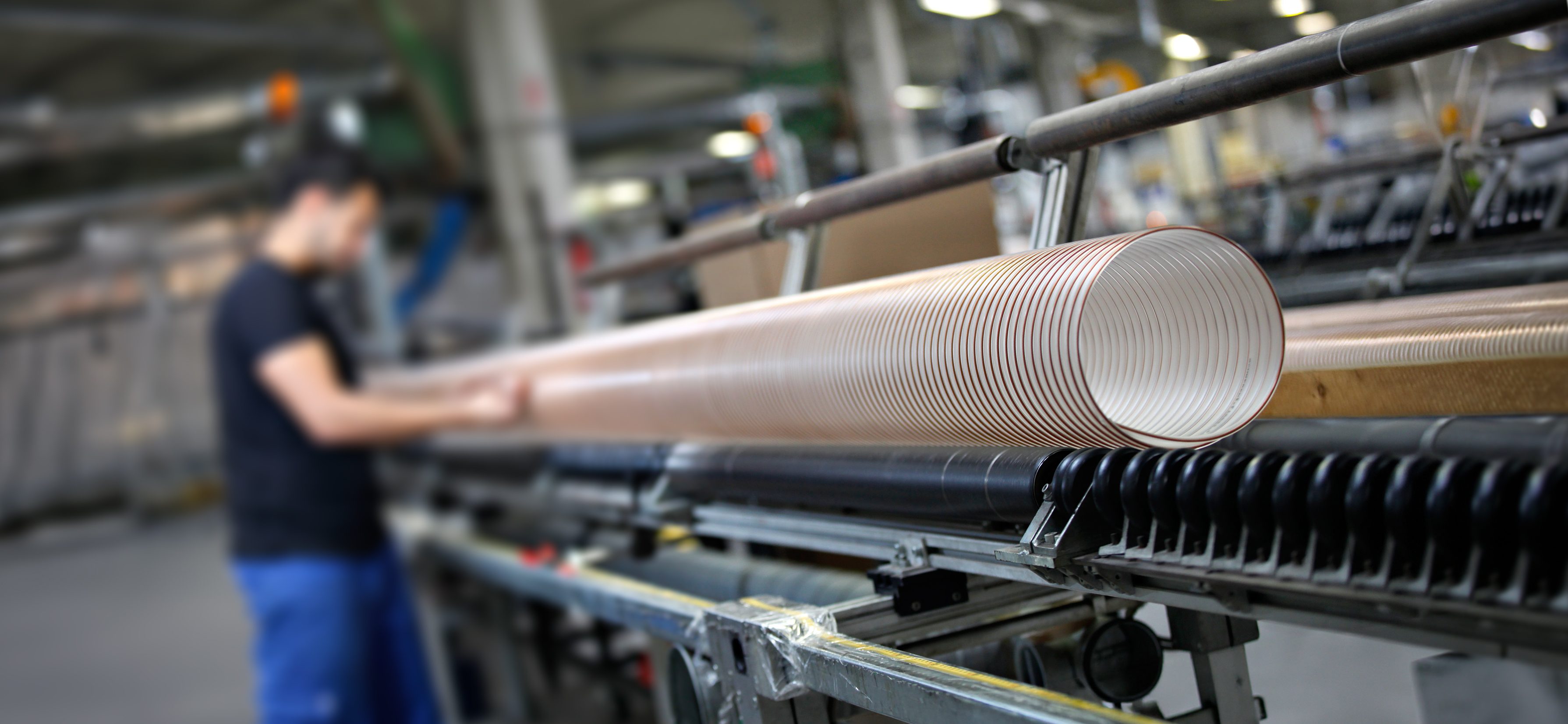 Foto da produção: Funcionário em uma máquina de produção de mangueiras em espiral