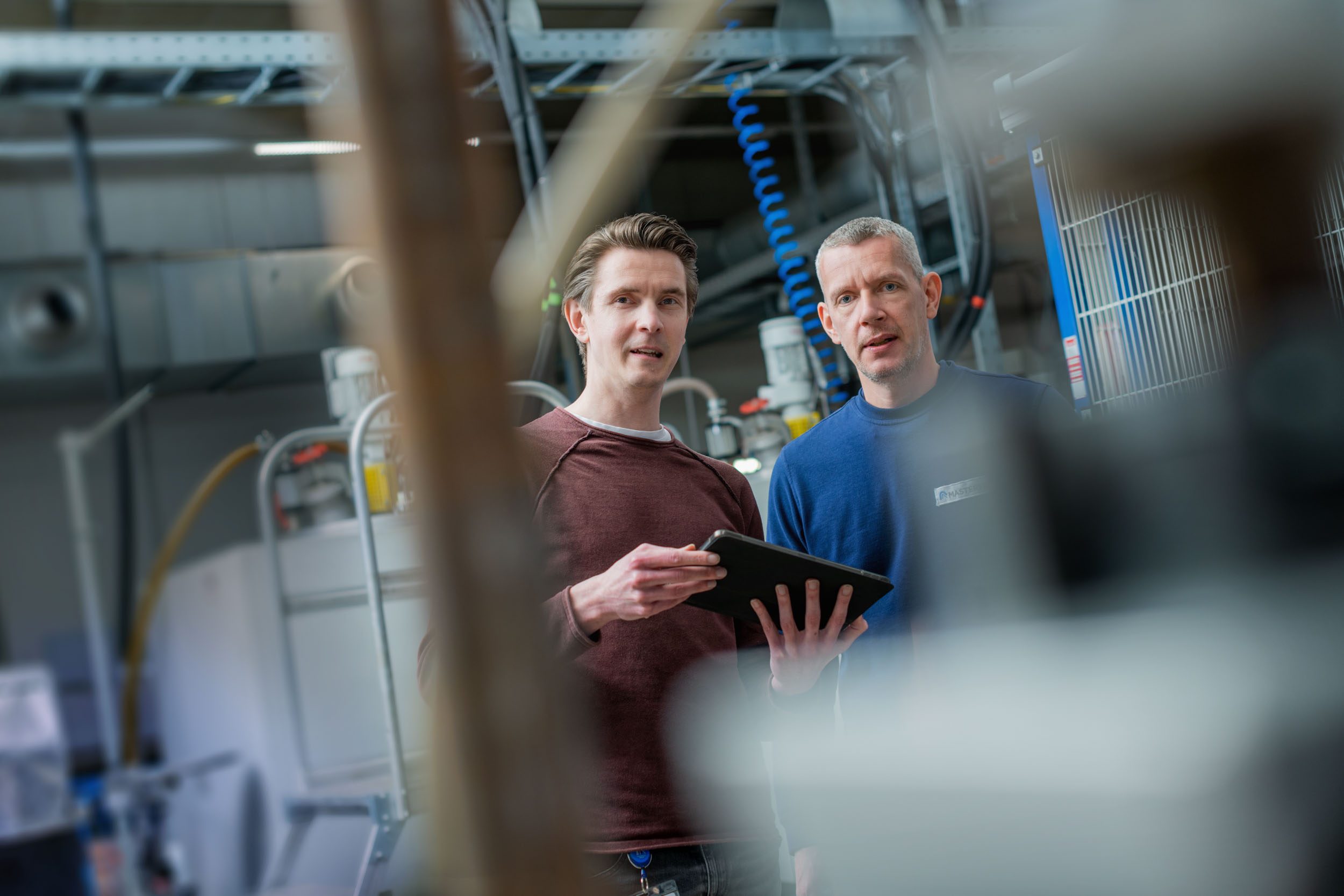Example image: employees standing with an ipad at the Gelsenkirchen production site