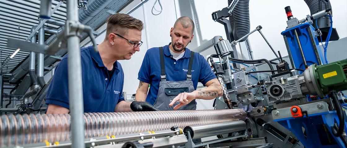 Dois funcionários em diálogo em uma máquina de produção