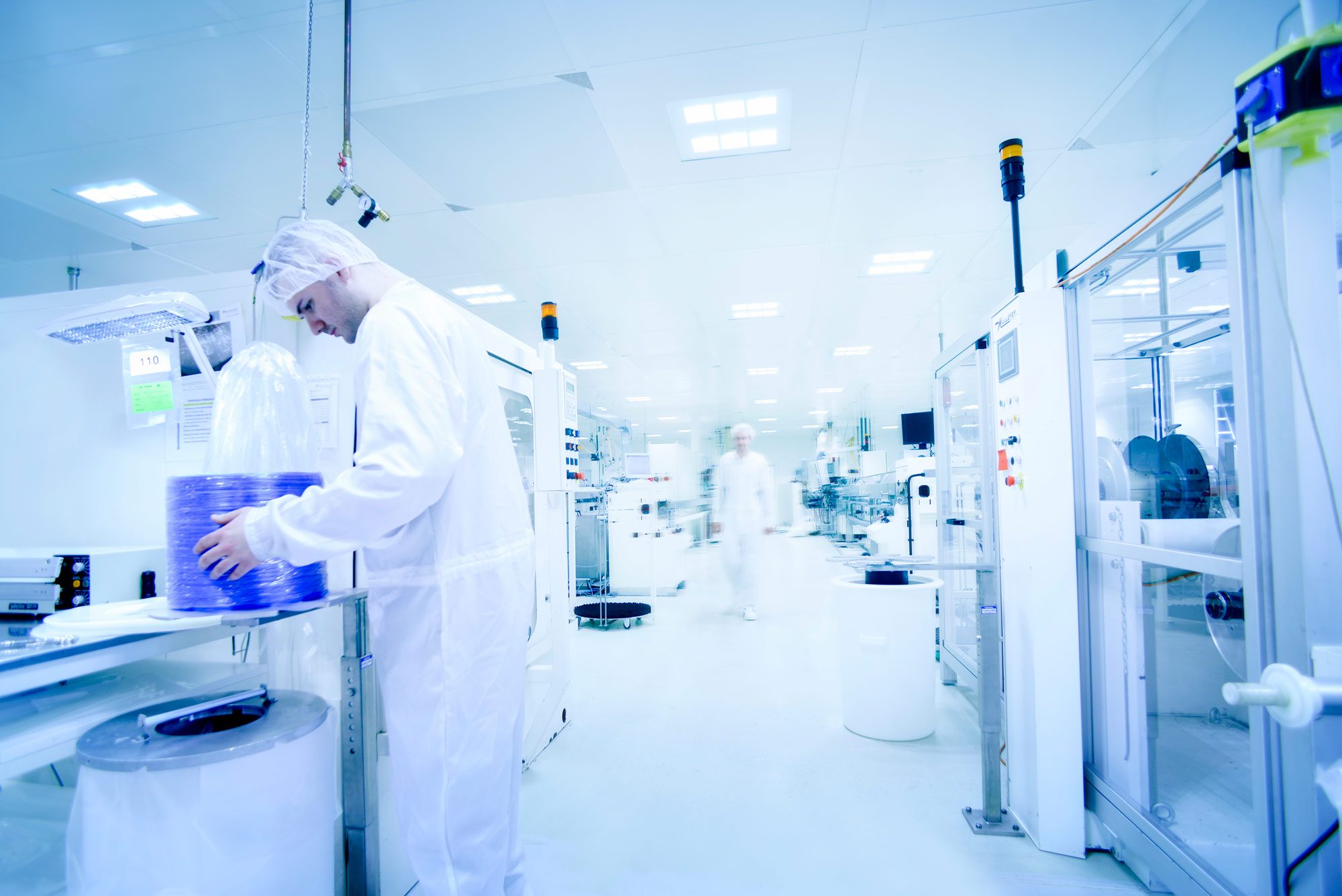 An employee checks the blue medical tubing produced in the clean room. 